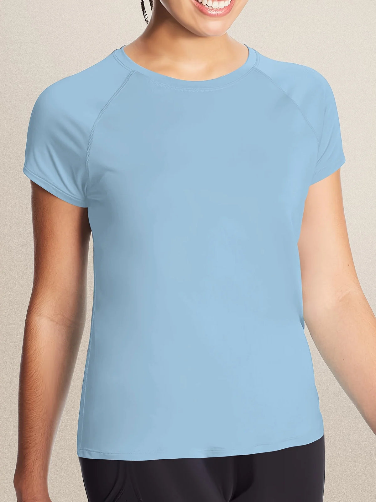 A light blue women's quick dry moisture-wicking gym t-shirt being worn by a model.