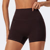 A close-up of a woman wearing dark brown high-waist yoga and workout shorts.