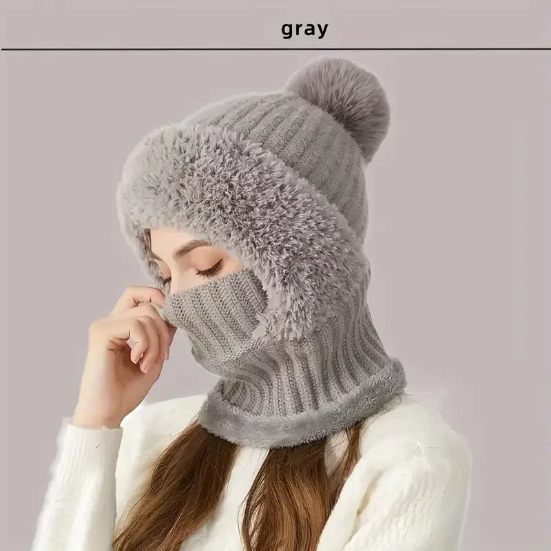 Model trägt eine graue Fleece-Mütze mit winddichten Ohrenschutz.