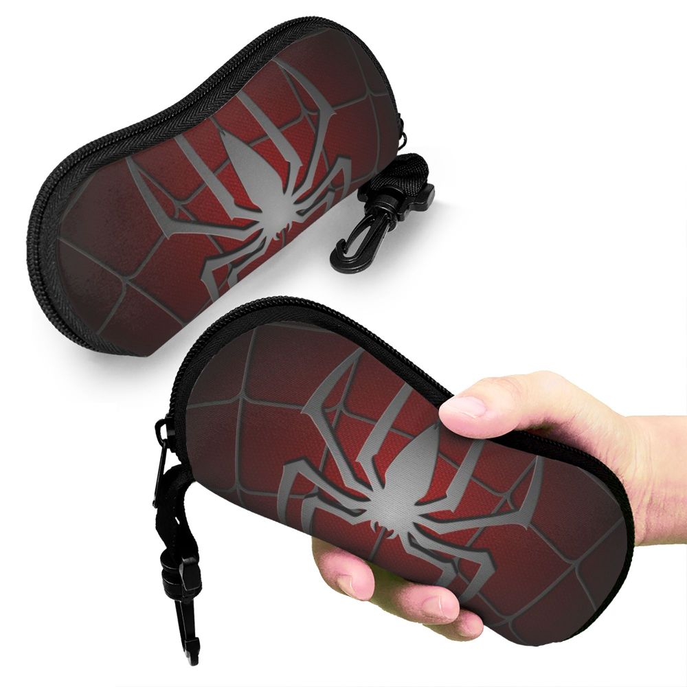 A dark red neoprene pouch featuring a silver spider web design, being held by a hand.