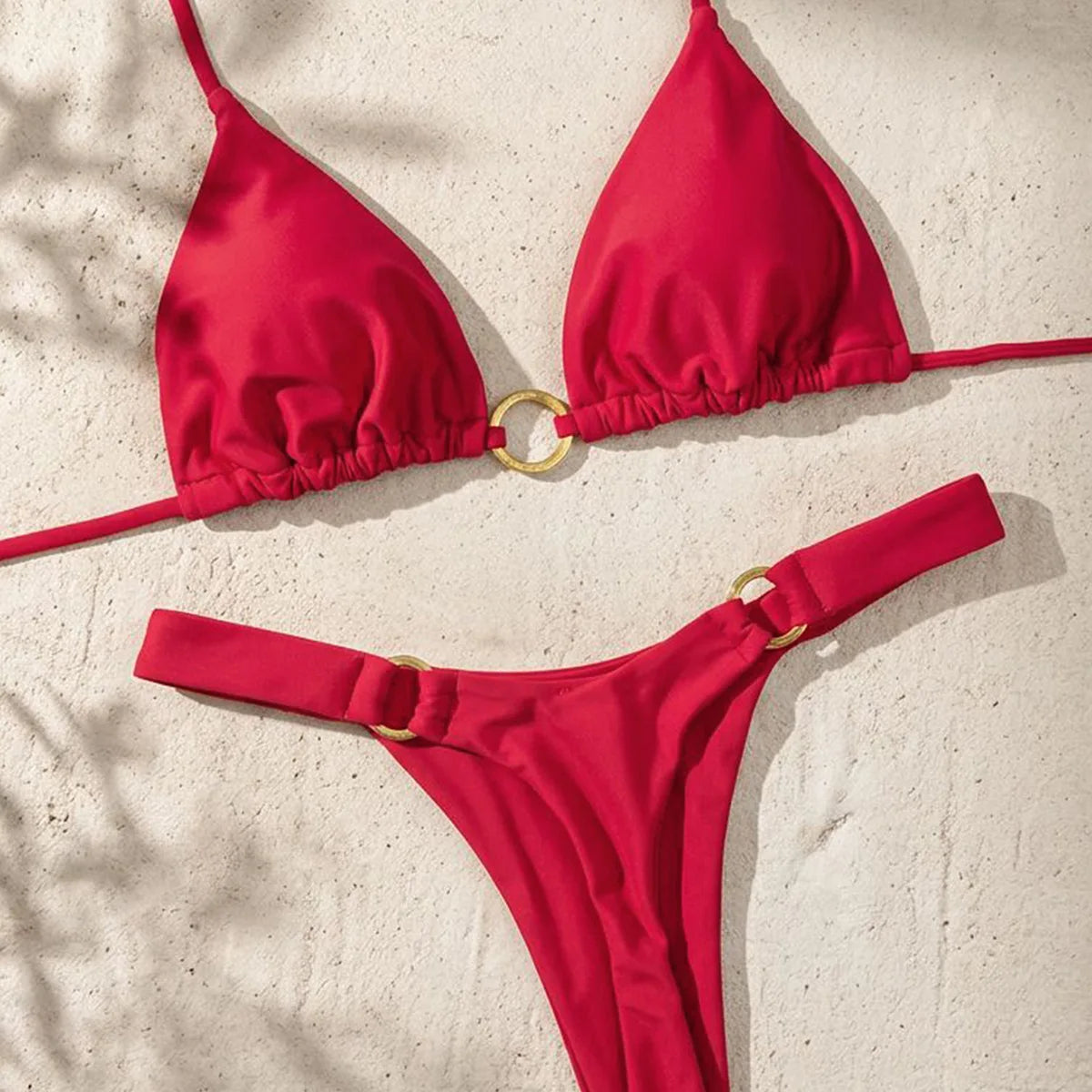 A red tie-side bikini set featuring a triangle top and matching bottoms, laid flat on a light surface.