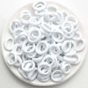 Haufen weißer Nylon-Elasthebändchen auf einem weißen Teller