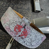 A light pink and black patterned leather belt featuring a samurai sword design.