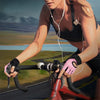 A woman wearing pink weightlifting gloves is exercising on a bicycle.