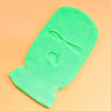 A bright lime green tactical knit balaclava beanie hat lying flat on a peach-colored surface.