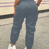 A person wearing gray high-waist drawstring cargo joggers standing outdoors.
