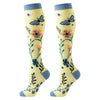 Pair of knee-high compression socks featuring a yellow background with floral and butterfly patterns.