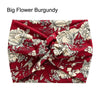 A burgundy floral fabric headband tied in a cross knot for yoga or workout.
