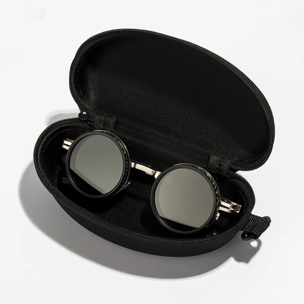 A black velvet pouch containing a pair of round sunglasses with gold-toned frames.