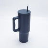 Tasse isotherme en acier inoxydable gris foncé avec anse et paille, vue de côté.