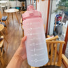 Una mano sostiene una botella de agua deportiva rosa con una pajita contra un fondo interior desenfocado.
