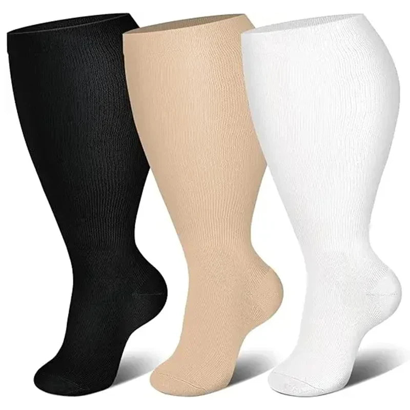 Three pairs of compression socks in black, beige, and white shown standing upright.