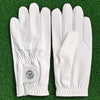 A pair of white men's breathable golf gloves lying on green grass.