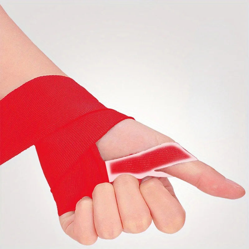 A hand is wrapped with a bright red professional cotton boxing hand wrap on the fingers and wrist.
