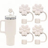 A white silicone straw cover set with flower-shaped tops and silicone grips for tumblers and water bottles