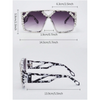 A pair of geometric rhinestone fashion sunglasses with black and white patterned frames.