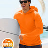 Ein Mann mit orangefarbener, leichter Hoodie und Sonnenbrille steht am Ozean mit UV-Schutz-Etikett.