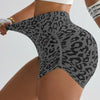 A woman wearing leopard print high-waist seamless shorts and a white crop top.
