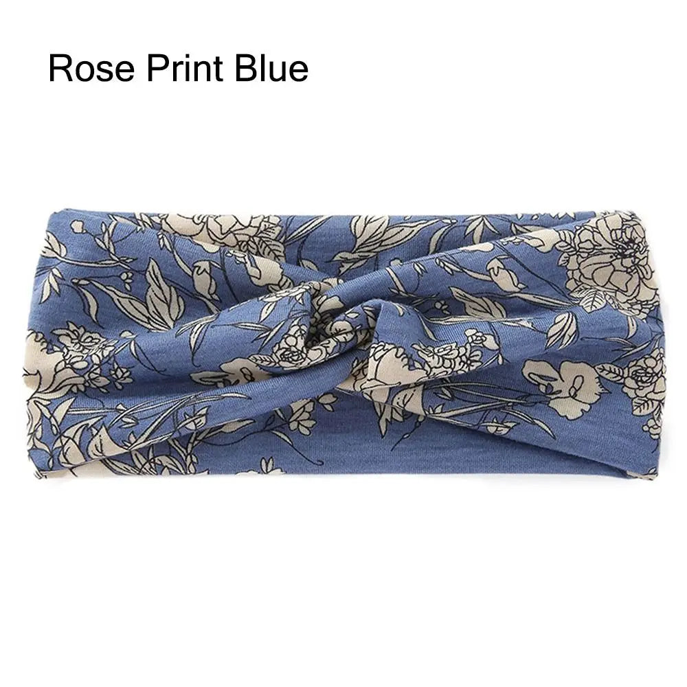 Diadema de tela azul con estampado floral en tonos rosa y beige.