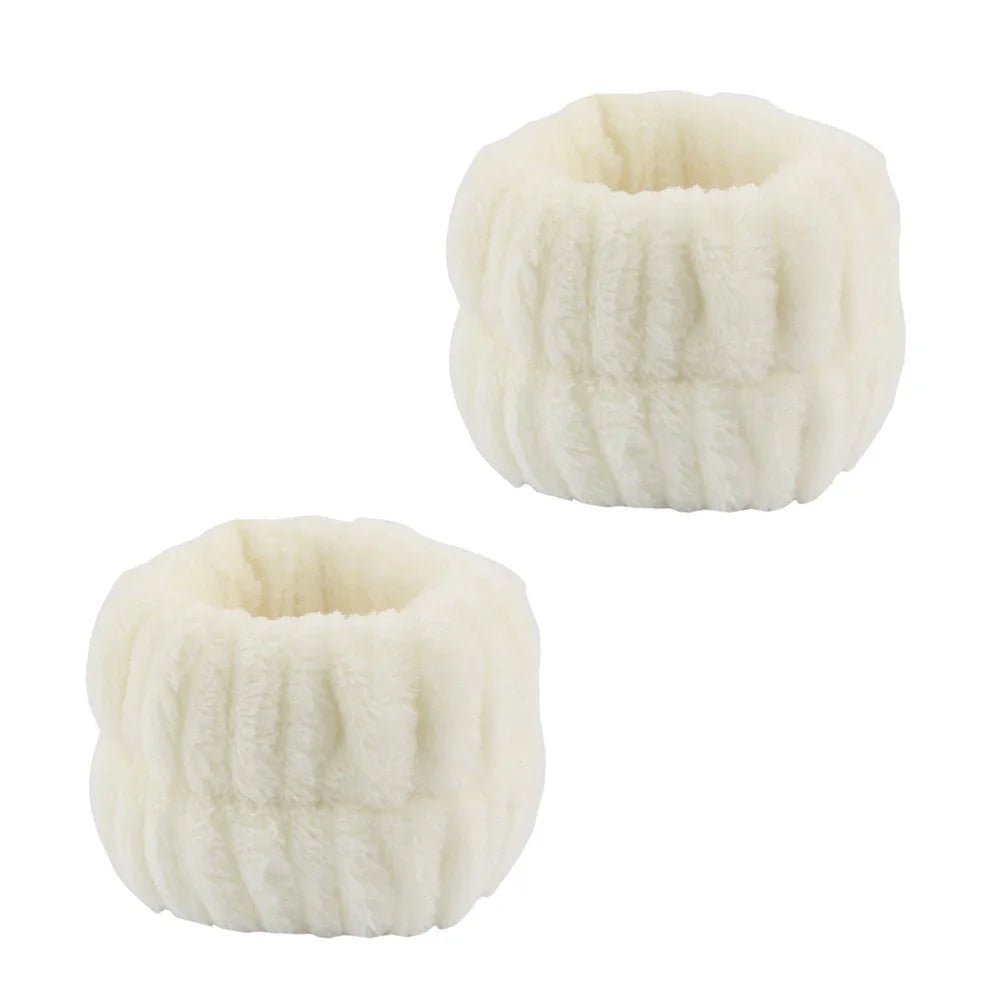 A set of white microfiber spa headband and wristband, fluffy texture.