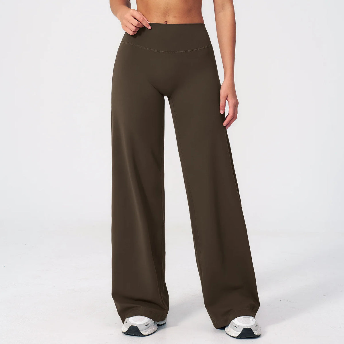 A woman wearing dark olive green high-waist flared yoga pants.