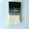 A pair of black and cream striped socks with the 'dlo' logo visible on the cuff.