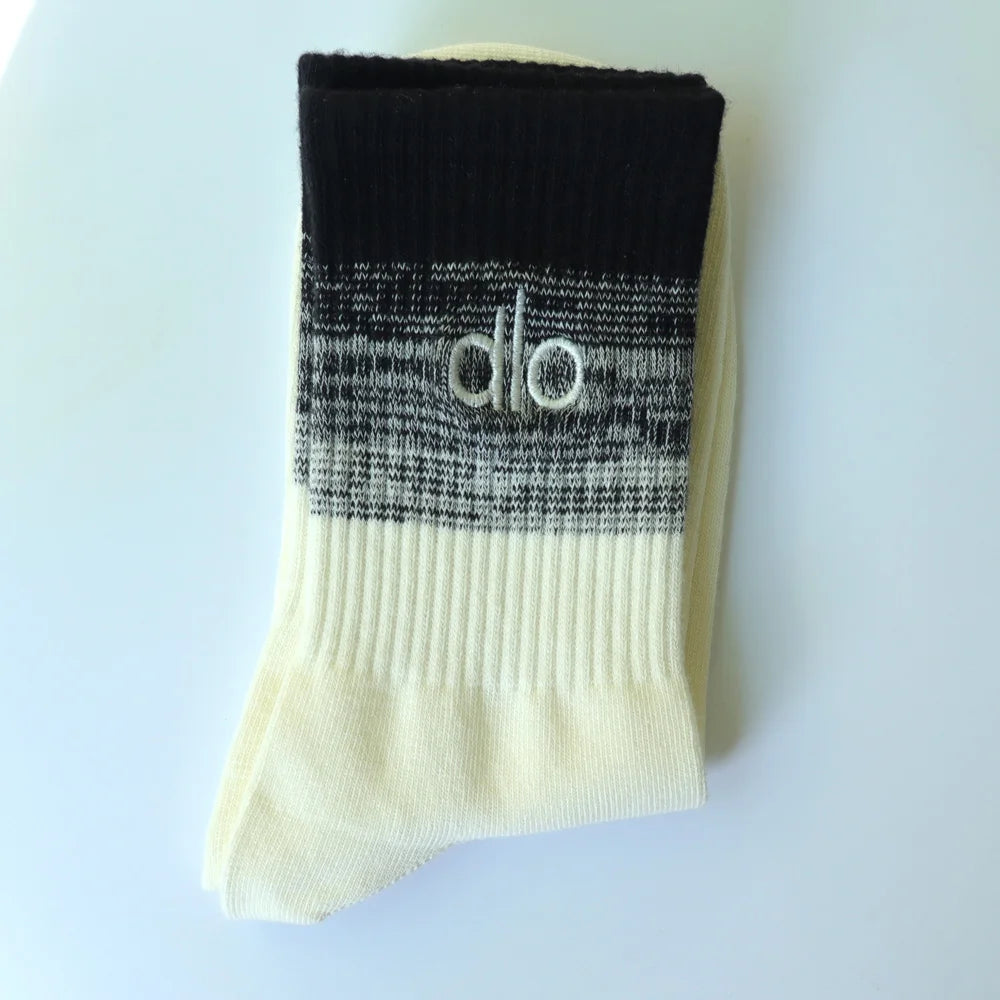 A pair of black and cream striped socks with the 'dlo' logo visible on the cuff.