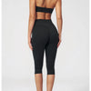 A woman models a black women's premium fitness tracksuit top and leggings.