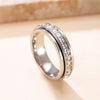 A silver stainless steel statement ring featuring a band and pave setting of cubic zirconia gemstones.