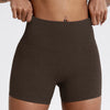 Un mannequin porte des shorts de yoga et de sport à taille haute en compression de couleur marron foncé.
