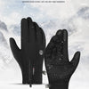Une paire de gants d'extérieur noirs chauds, présentés sur un fond enneigé.