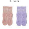 Two pairs of pink and purple grip socks for yoga and barre