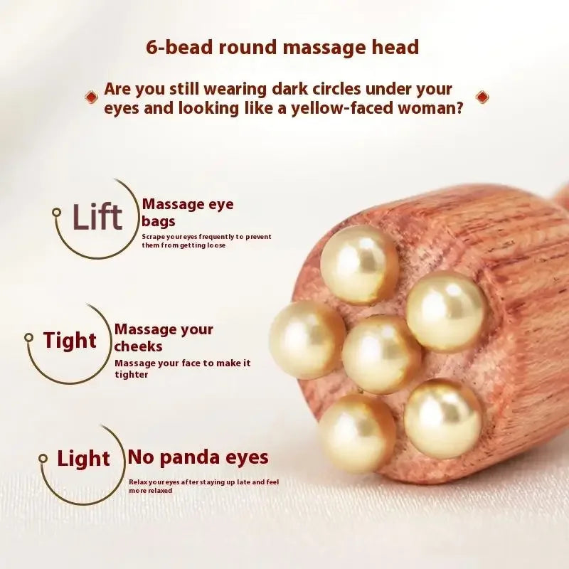 A wooden massage stick with six pearl-like beads used for eye and cheek massage.
