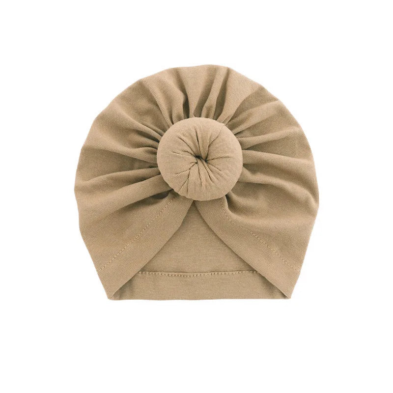 Beiger, fester Baumwoll-Babyturban in gefalteter Form.