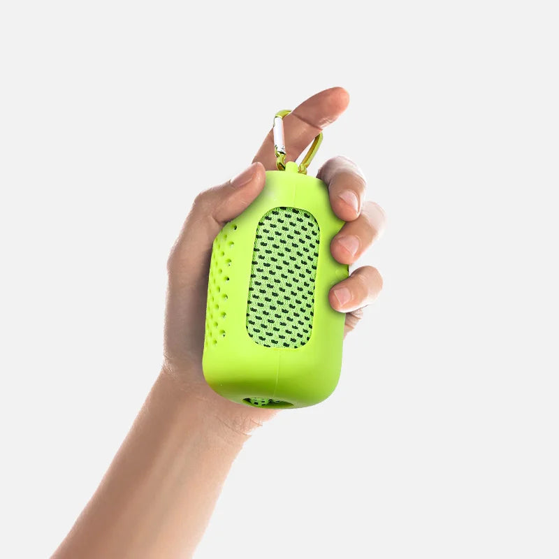 A hand is holding a bright lime green cooling towel with a mesh texture and a loop for hanging.