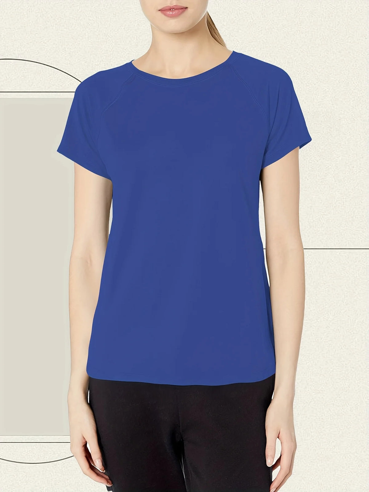 A woman wearing a royal blue quick dry moisture-wicking gym t-shirt and black pants.