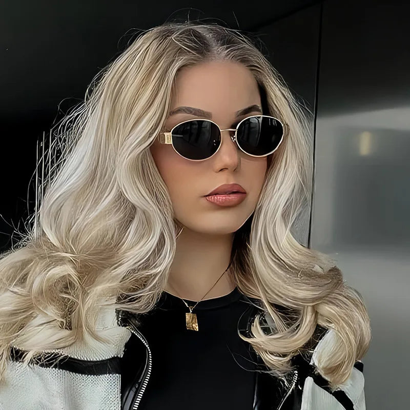 A woman models classic oval metal sunglasses with long blonde hair against a dark background.