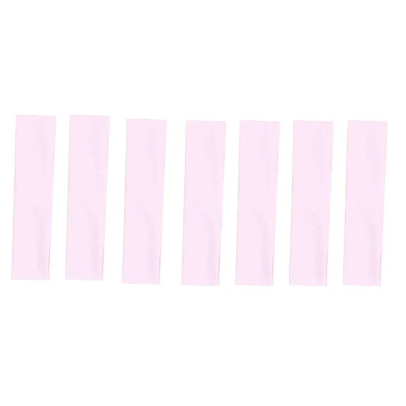 A set of solid pink elastic hair bands arranged in a row.