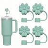 A teal silicone straw cover and tumbler set with multiple flower-shaped silicone covers.