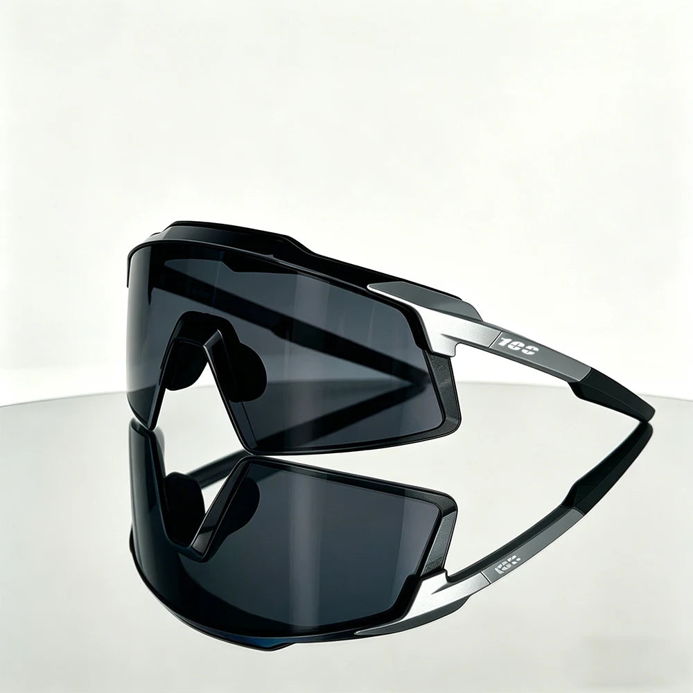 A pair of black TR90 UV400 sports sunglasses resting on a reflective surface.
