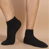 A pair of black breathable unisex boat socks worn on a person's feet.
