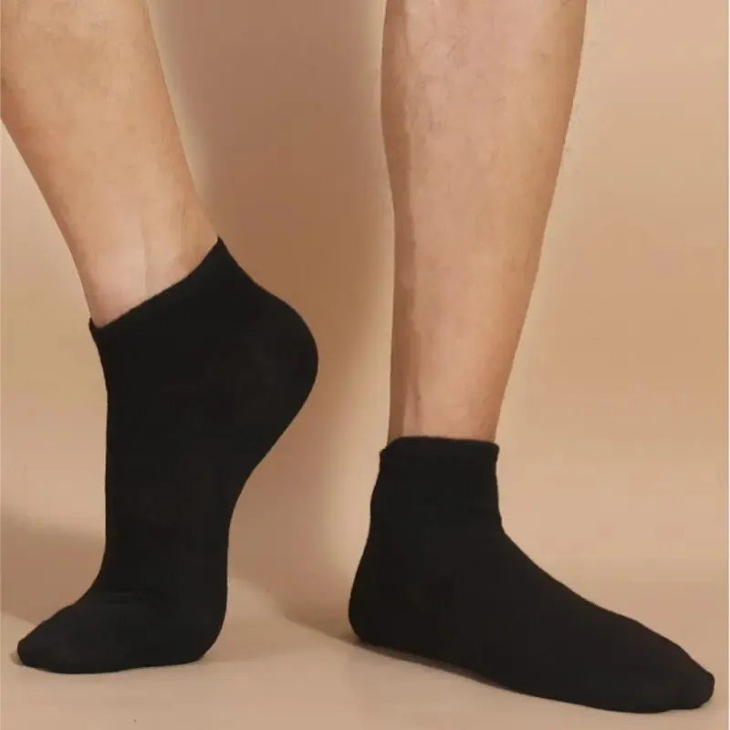 A pair of black breathable unisex boat socks worn on a person's feet.