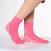 Pink dotted yoga socks worn on a foot, showing the texture and design.