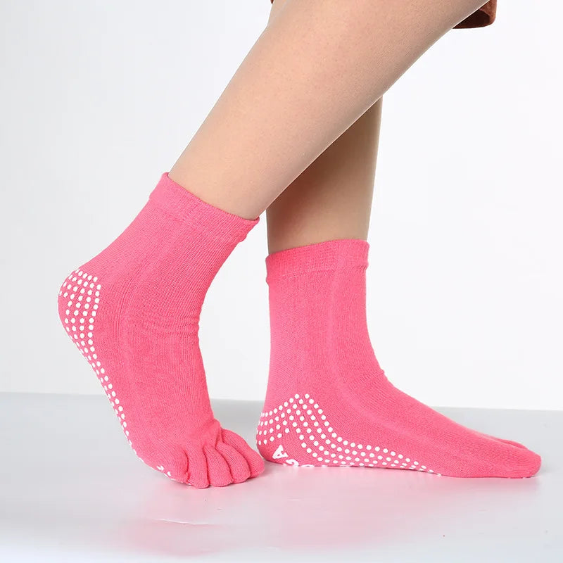 Pink dotted yoga socks worn on a foot, showing the texture and design.