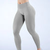 Primer plano de un legging de yoga sin costuras de cintura alta en gris, mostrado en las piernas de una modelo.