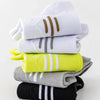 A stack of premium breathable men's running socks in white, gray, lime green, and black.
