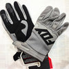 A pair of gray and black durable motorcycle off-road riding gloves are displayed on a white surface.