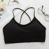 Black women's cross strap sports bra laid flat on a white surface.