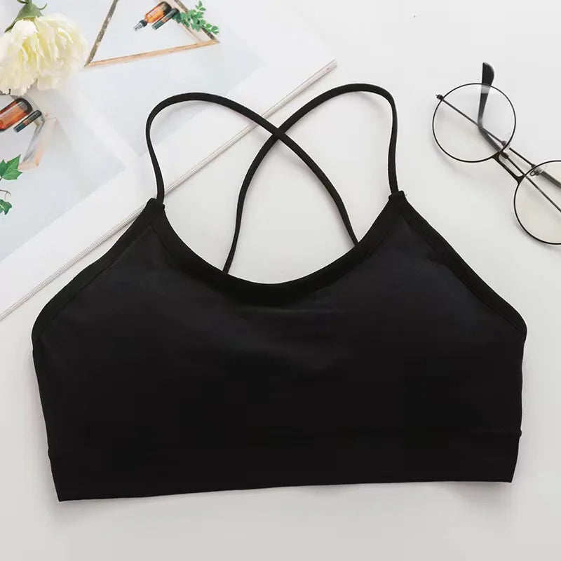 Black women's cross strap sports bra laid flat on a white surface.