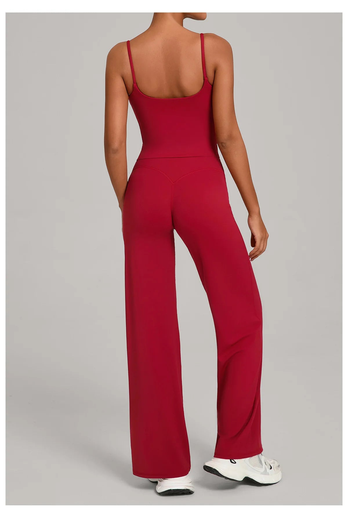 A woman models a red high-waist yoga and fitness tracksuit set featuring a long-sleeved top and matching pants.